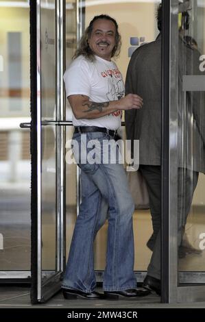 Il concorrente di 'X-Factor' Wagner Fiuza-Carrilho indossa una t shirt "Everybody was Kung-fu Fighting" mentre gioca un ruolo di scherzo su alcune giovani donne in una porta girevole in un edificio ITV. Londra, Regno Unito. 10/27/10. . Foto Stock