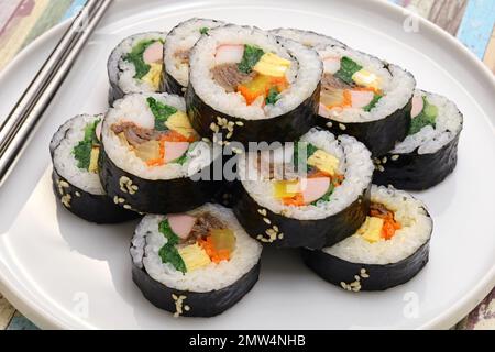 Gimbap è un cibo coreano composto da riso e diversi ingredienti conditi con olio di sesamo e avvolti in nori alghe. Foto Stock