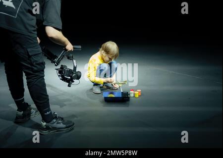 Russia, Mosca 06.15.2022. il videografo scatta su una videocamera, come piccolo bambino di sei anni che dipinge o colorisce o modella il velivolo a colori con goua Foto Stock