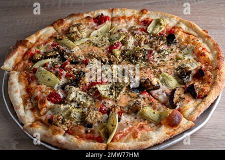 Pizza gourmet con carciofo, pomodoro essiccato al sole, melanzane, salsa di pomodoro, su crosta sottile Foto Stock