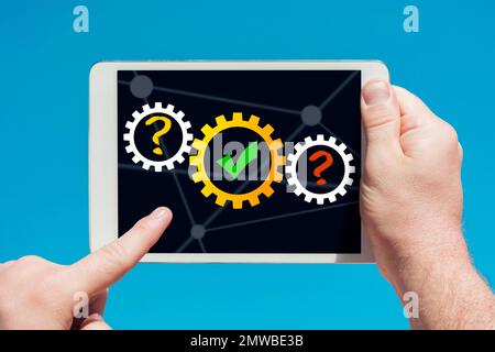 Un uomo con un tablet che mostra un concetto di pensiero e di successo su sfondo blu Foto Stock
