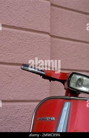 Manubri e parte anteriore di uno scooter rosso davanti a una parete rosa della casa, Vespa, Svizzera Foto Stock