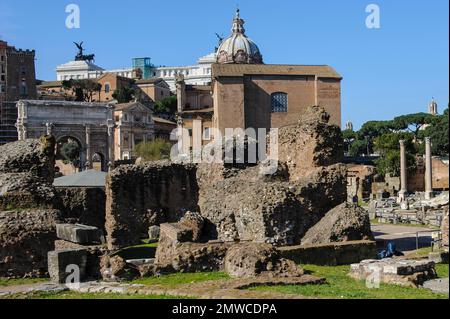 Rovina con mura di fondazione e fondazione del tempio di Gaio Giulio Cesare, Divus Iulius, dietro di esso storico edificio di incontro del Senato di Foto Stock