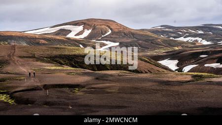 Due escursionisti sul Laugavegur, paesaggio vicino Landmannalaugar, paesaggio vulcanico drammatico, paesaggio di erosione colorata con montagne, campo di Lava Foto Stock