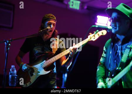 Un cantante che canta e suona la chitarra durante un concerto Rock and Roll dal vivo in un bar Foto Stock