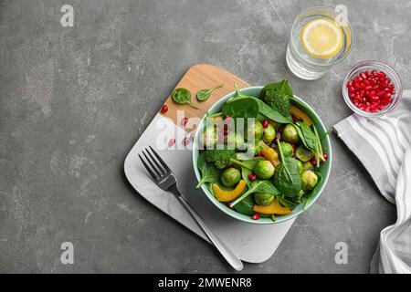 Gustosa insalata con germogli di Bruxelles servita su un tavolo grigio, piatto Foto Stock