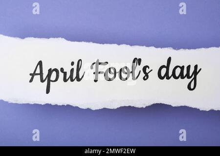 Nota cartacea con frase FOOL's DAY aprile su sfondo lilla, vista dall'alto Foto Stock