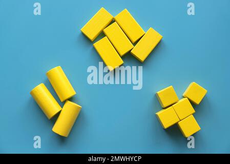 Concetto di categoria. La forma diversa del blocco di geometria in legno giallo si riorganizza nella sua categoria. Foto Stock