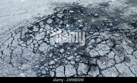 Strada asfaltata con crepa. Danneggiato e rotto. Foto Stock