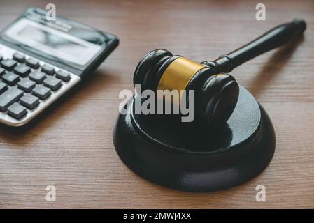 Diritto e finanza. Bankcruptcy, diritto fiscale, corruzione, arbitrato, Penalty Concept.Gavel e calcolatrice su sfondo di legno. Foto Stock