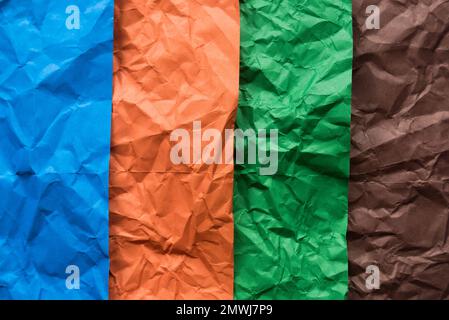 Carta stropicciata blu, arancione, verde e marrone per lo sfondo. Foto Stock