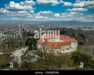 Veduta aerea del castello medievale di Pezinok (Bazin) con tetto rosso restaurato e centro medievale di commercio del vino con chiesa gotica e tracce di mura della città Foto Stock