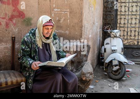 Il sacerdote copto legge la Bibbia per le strade di Zabbaleen (spazzatura) Città, il Cairo, Egitto Foto Stock