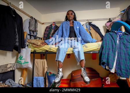 Nairobi, Kenya. 25th Jan, 2023. Cynthia Gesare di 20 anni posa sul suo letto all'interno della sua piccola stanza circondata da armadi a Kibera. I giovani kenioti sono spinti in una competenza di avere le proprie case lontano dai genitori, dove soprattutto imparano ad affrontare la vita attraverso diverse sfide. La competizione di avere le camere meglio decorate piene di diversi abiti di design è un modo per tenere lontano dalle sfide quotidiane della vita, come l'abuso di droghe, le gravidanze adolescenziali matrimoni precoci, e giudizi negativi da parte della gente del posto. Alla maggior parte dei giovani che hanno un hom Foto Stock