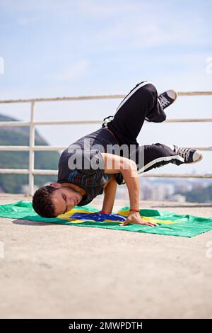 Capoeira- parte della cultura brasiliana. Inquadratura ad angolo basso di un giovane breakdancer maschile in un ambiente urbano. Foto Stock