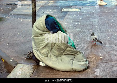 senza casa che prega per strada Foto Stock