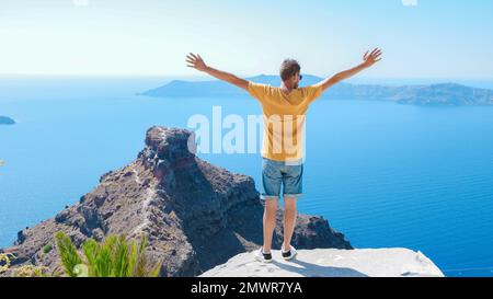 I giovani turisti visitano Oia Santorini Grecia in una giornata di sole durante l'estate con case e chiese imbiancate, l'isola greca Cicladi del Mar Egeo Foto Stock