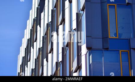 Edificio in vetro con facciata trasparente dell'edificio e cielo blu. Parete strutturale in vetro che riflette il cielo blu. Frammento astratto di architettura moderna. Foto Stock