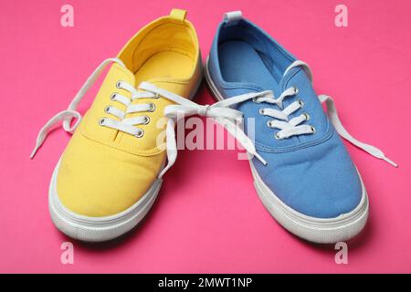 Scarpe legate insieme su sfondo rosa. Fool's Day di aprile Foto Stock