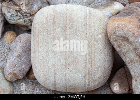 Quando visitiamo una spiaggia, non siamo a conoscenza dei materiali che ci circondano. Dettaglio Fotografia delle pietre e della sabbia su una spiaggia asturiana. Foto Stock