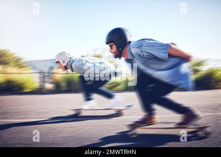 Sport, velocità e sfocatura, gara di longboard su strada con uomini che corrono in discesa su skateboard con casco di sicurezza. Avventura sportiva estrema, amici Foto Stock