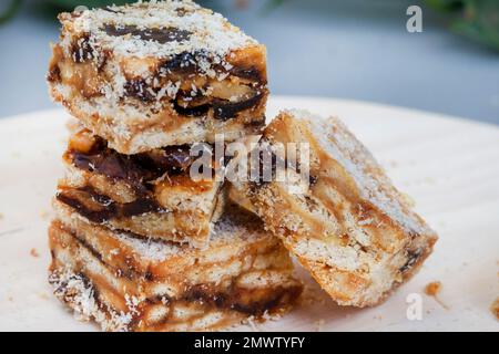 classici dateti cosparsi di cocco su una superficie di legno chiaro. Foto Stock