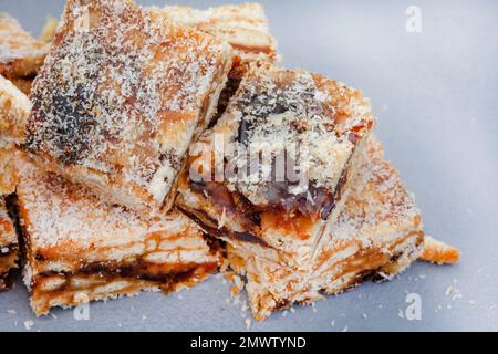 classici dateti cosparsi di cocco su una superficie di legno chiaro. Foto Stock