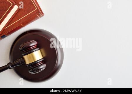 Sfondo con gavel di legno e libri di legge impilati isolati su tavola di wite. Vista dall'alto Foto Stock
