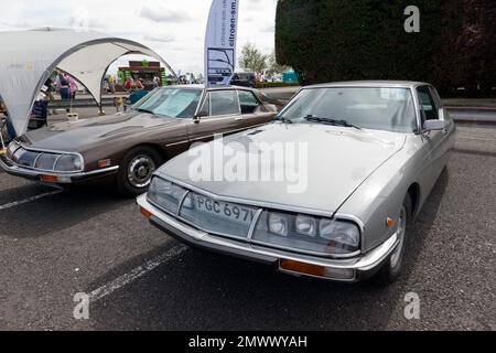 Vista frontale di tre quarti di due Citroen SM, in mostra al 2022 Silverstone Classic Foto Stock