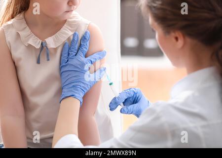 Bambina che riceve la vaccinazione contro la varicella in clinica. Prevenzione del virus della varicella Foto Stock