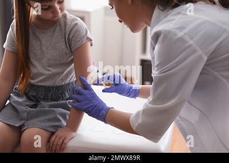 Bambina che riceve la vaccinazione contro la varicella in clinica. Prevenzione del virus della varicella Foto Stock