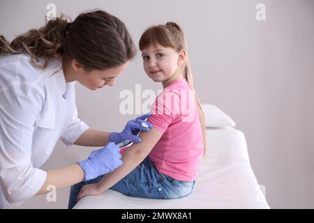 Bambina che riceve la vaccinazione contro la varicella in clinica. Prevenzione del virus della varicella Foto Stock