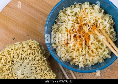 Fast food, tagliatelle cinesi con spezie sullo sfondo di legno Foto Stock