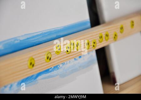 Adesivi facciali sorridenti su una libreria di legno, camera per bambini, adesivi felici Foto Stock