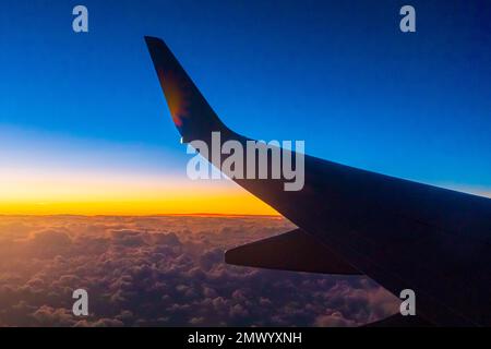 Vista dalla finestra passeggeri di un aeromobile Boeing 737 che sorvola le nuvole del tramonto. Foto Stock