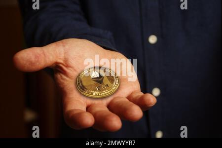 Ethereum ETH criptovaluta moneta d'oro in mano concetto astratto Foto Stock