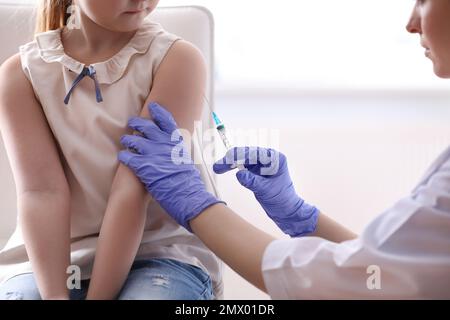 Bambina che riceve la vaccinazione contro la varicella in clinica. Prevenzione del virus della varicella Foto Stock