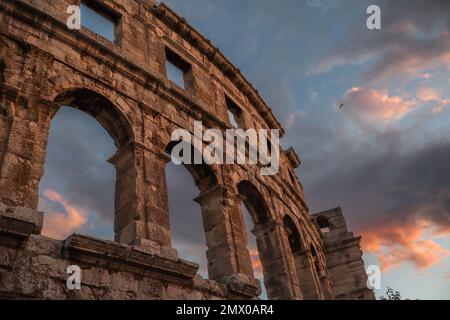 Pula Arena con il cielo del tramonto. Bellissimo anfiteatro romano in Croazia durante l'ora d'oro estiva. Foto Stock