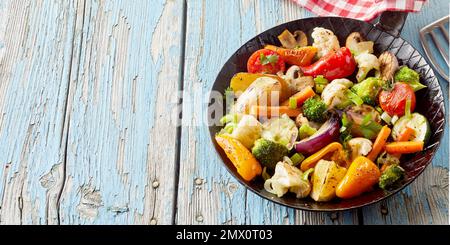 Da sopra verdure fritte assortite e salutari servite per pranzo in padella su un tavolo di legno shabby Foto Stock