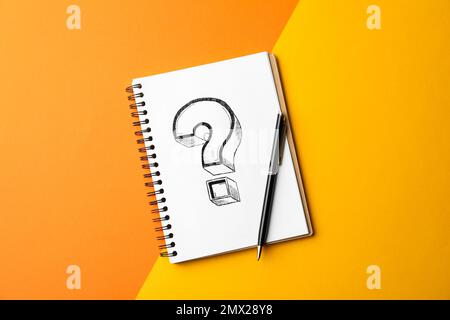 Notebook con punto interrogativo e penna su sfondo a colori, vista dall'alto Foto Stock