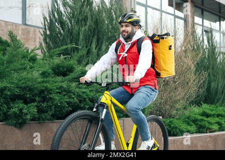 Corriere con borsa termica in bicicletta all'aperto. Servizio di consegna cibo Foto Stock