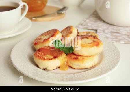 Deliziosi pancake al formaggio casolare con menta su tavolo bianco Foto Stock