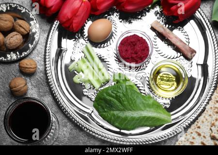 Composizione piana con piastra di sicurezza Passover (keara) su tavolo grigio. Festa di Pesah Foto Stock