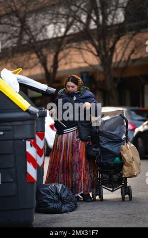 zingari alla ricerca di cose utili in spazzatura bidoni, roma, italia. problemi di città. concetto di vita cittadina Foto Stock