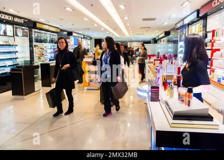 Parigi, Francia, donna cinese, turista, guardando lo smartphone mentre si fa shopping nei grandi magazzini francesi, Galeries Lafayette Foto Stock