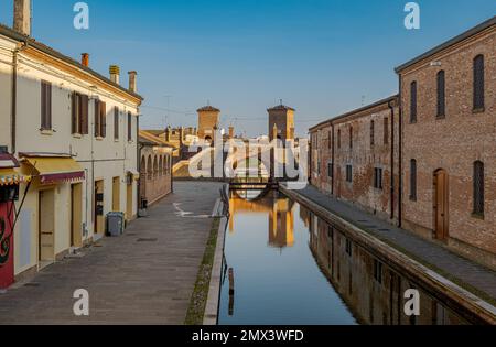 Vista prospettica di un canale di Comacchio con sullo sfondo il famoso ponte a tre vie. Comacchio, provincia di Ferrara, Emilia Romagna, Italia. Foto Stock