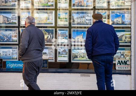 Foto datata febbraio 2nd mostra le persone che cercano nelle finestre degli agenti immobiliari a Ely, Cambs, il Giovedi mattina come è annunciato ci sarà un altro inc Foto Stock