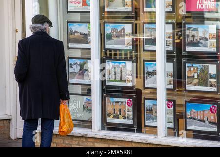 Foto datata febbraio 2nd mostra le persone che cercano nelle finestre degli agenti immobiliari a Ely, Cambs, il Giovedi mattina come è annunciato ci sarà un altro inc Foto Stock