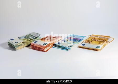 Pile di banconote, del valore di cinque, dieci, venti e cinquanta euro su sfondo grigio chiaro, concetto di valuta, business, finanza e inflazione, copia Foto Stock