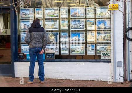 Foto datata febbraio 2nd mostra le persone che cercano nelle finestre degli agenti immobiliari a Ely, Cambs, il Giovedi mattina come è annunciato ci sarà un altro inc Foto Stock